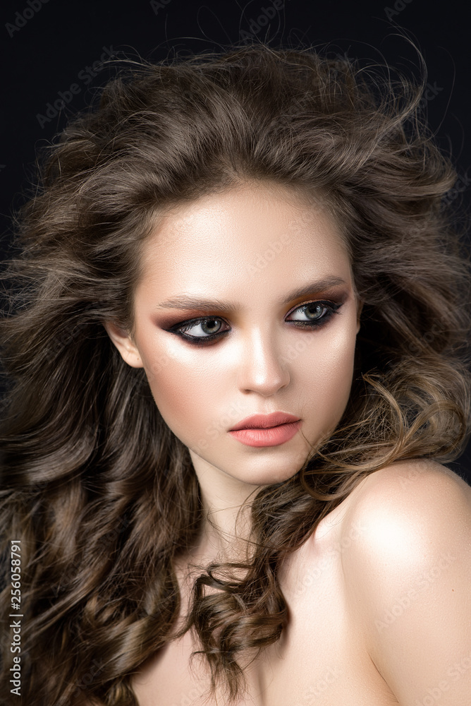 Fototapeta premium A girl with beautiful golden eye makeup and curly hair