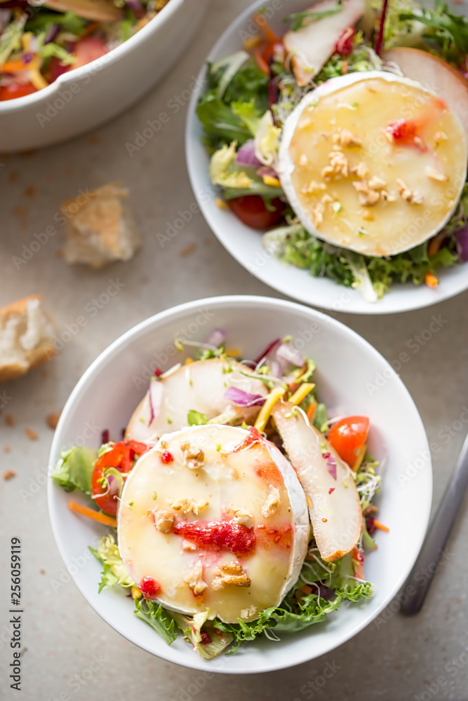 Salad with lettuce, fried pears, camembert, walnuts, red onion, tomatoes and raspberry vinaigrette dressing Salad with lettuce, fried pears, camembert, walnuts, red onion, tomatoes and raspberry vinaigrette dressing