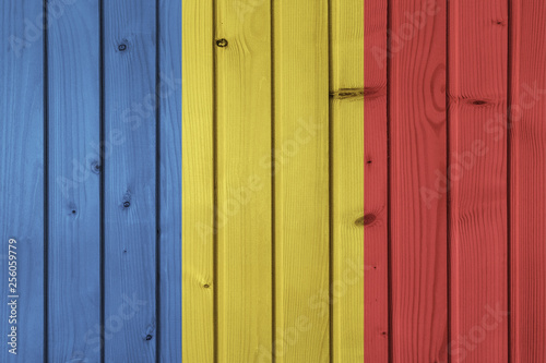 Flag of Romania on the background of wooden boards. Wallpaper for installation and design. Space for text.