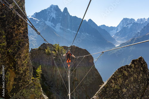 Mountaineer crossing cable bridge via ferrata, Chamonix France. photo