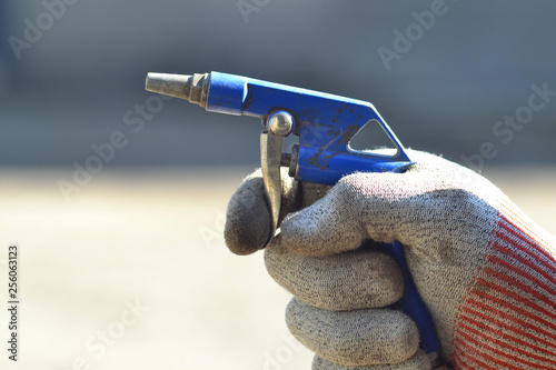 Compressed air gun in the hand of a worker.