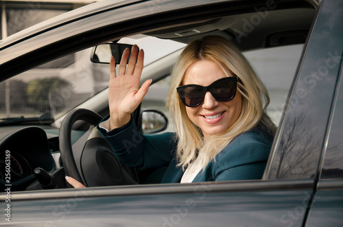 Blonde young woman waving from the car  © phoenix021