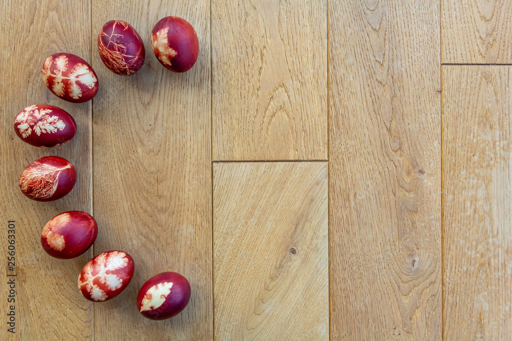 Easter eggs dyed with onion peels with a pattern of plants and leaves, lying on a wooden background. Top view with copy space. Symbol of Christian tradition. Easter eggs dyed with onion peels with a pattern of plants and leaves, lying on a wooden background. Top view with copy space. Symbol of Christian tradition.