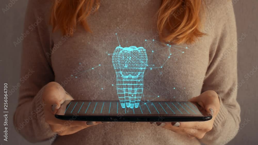 Hologram screen on a tablet with digital datas, tooth and particles