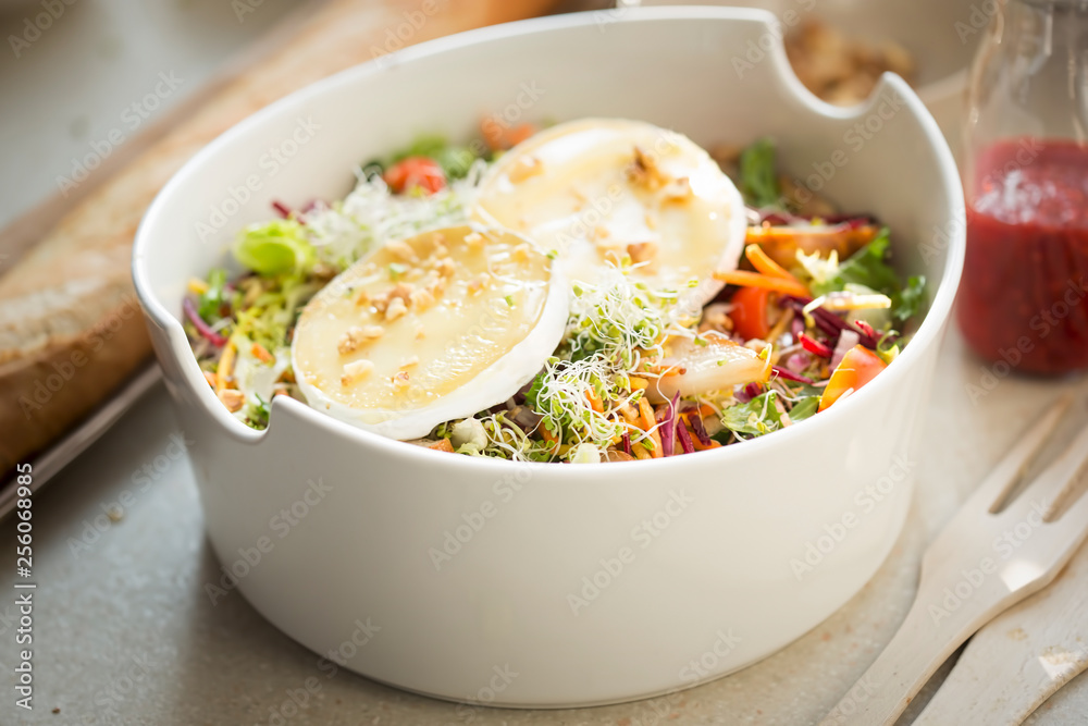 Salad with lettuce, fried pears, camembert, walnuts, red onion, tomatoes and raspberry vinaigrette dressing