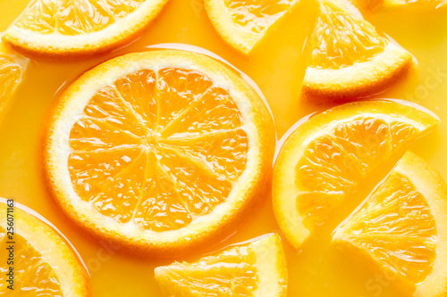 top view of orange slices in juice as background