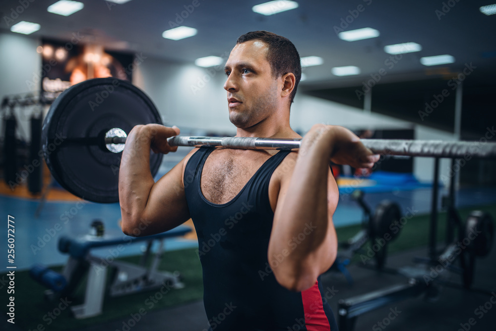 Strong powerlifter doing deadlift a barbell in gym Strong powerlifter doing deadlift a barbell in gym