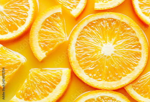 top view of orange slices in juice as background