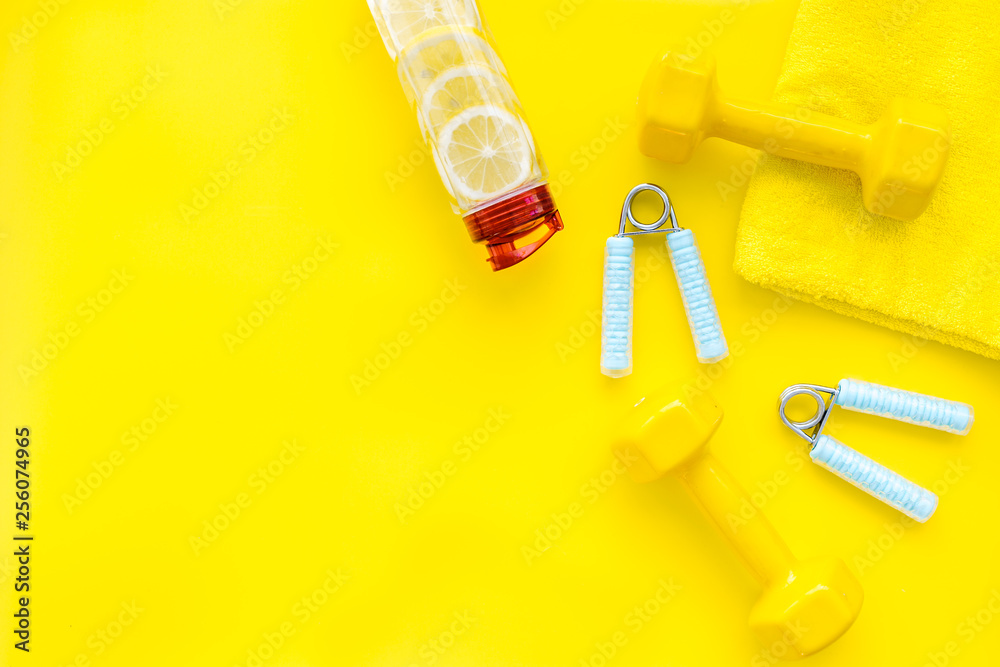 workout with bars, bottle of water and wrist builder yellow background top view mockup workout with bars, bottle of water and wrist builder yellow background top view mockup