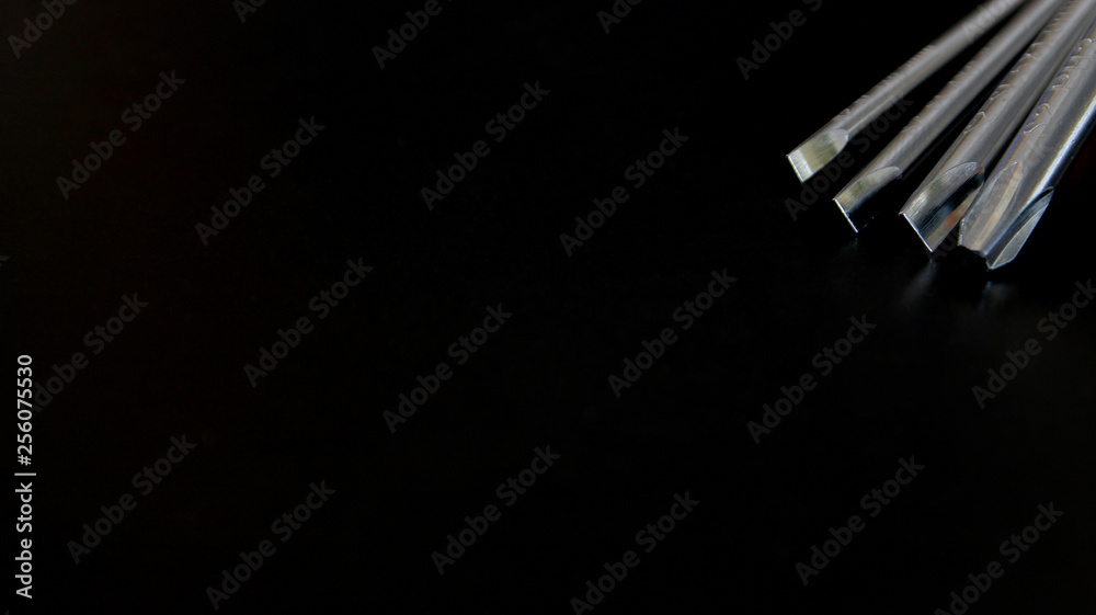 Metal screwdrivers tool isolated on black background. Closeup, selective focus. Screwdrivers with shadows. Metal screwdrivers tool isolated on black background. Closeup, selective focus. Screwdrivers with shadows.