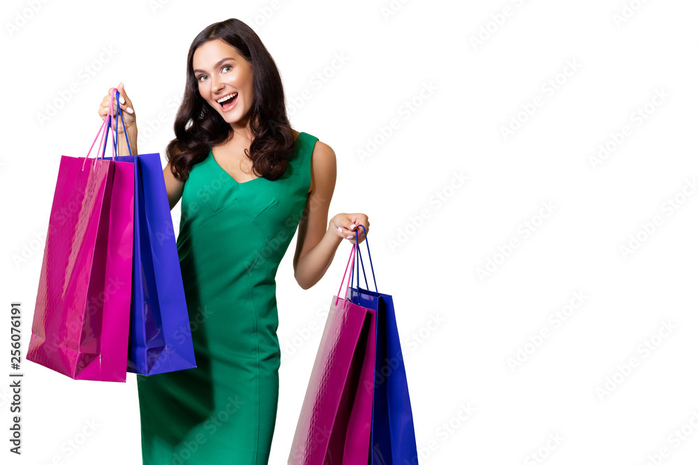 Happy young woman wearing green dress standing isolated over white background, carrying shopping bags. satisfied girl after successful shopping in the mall. copy space. sale. - Image .    