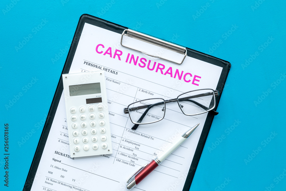 Car insurance form near glasses, calculator, pen on blue background top view Car insurance form near glasses, calculator, pen on blue background top view