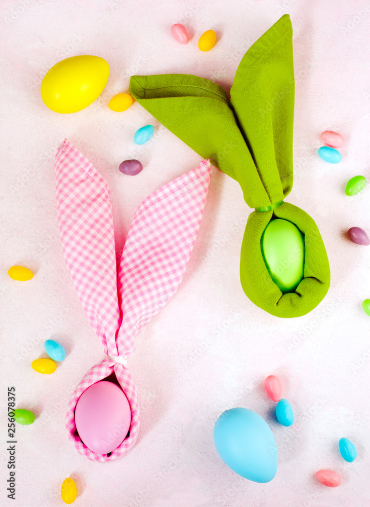 Napkin Easter Bunny, decoration eggs and Easter candy on pink background. Napkin Easter Bunny, decoration eggs and Easter candy on pink background.