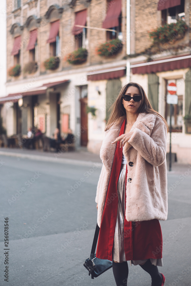 young beautiful stylish woman walking in pink coat