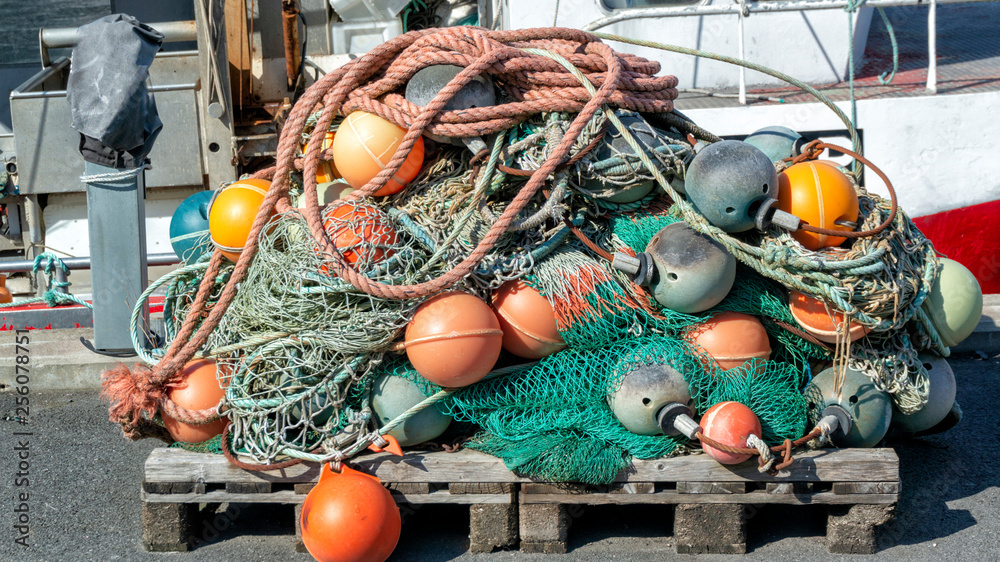 Long fishing net, longitudinal and round colorful red and yellow fishing  buoys Stock Photo