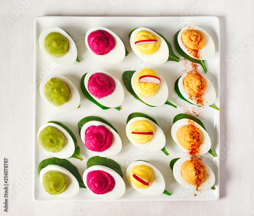 A plate of deviled eggs on dark grey stone background, top view