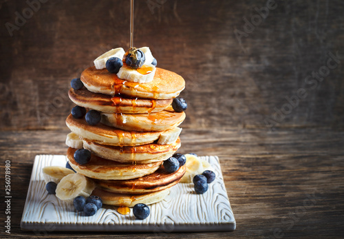 Pancakes with banana, blueberry and maple syrup for a breakfast photo