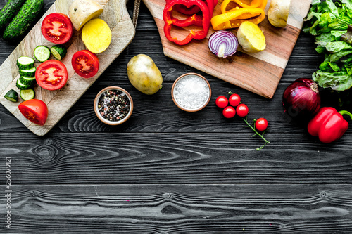 Fresh food ingredients for vegetarian kitchen on black wooden background top view mock-up