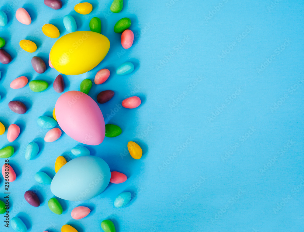 Easter decoration eggs and candy on blue background. Easter background