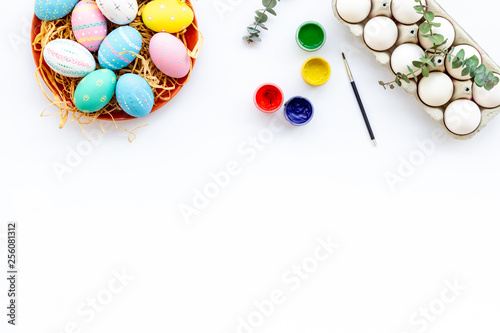 eggs with colorful paint for easter tradition on white background top view mockup