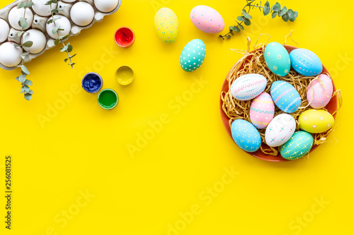 paint eggs for Easter celebration on yellow background top view mock up