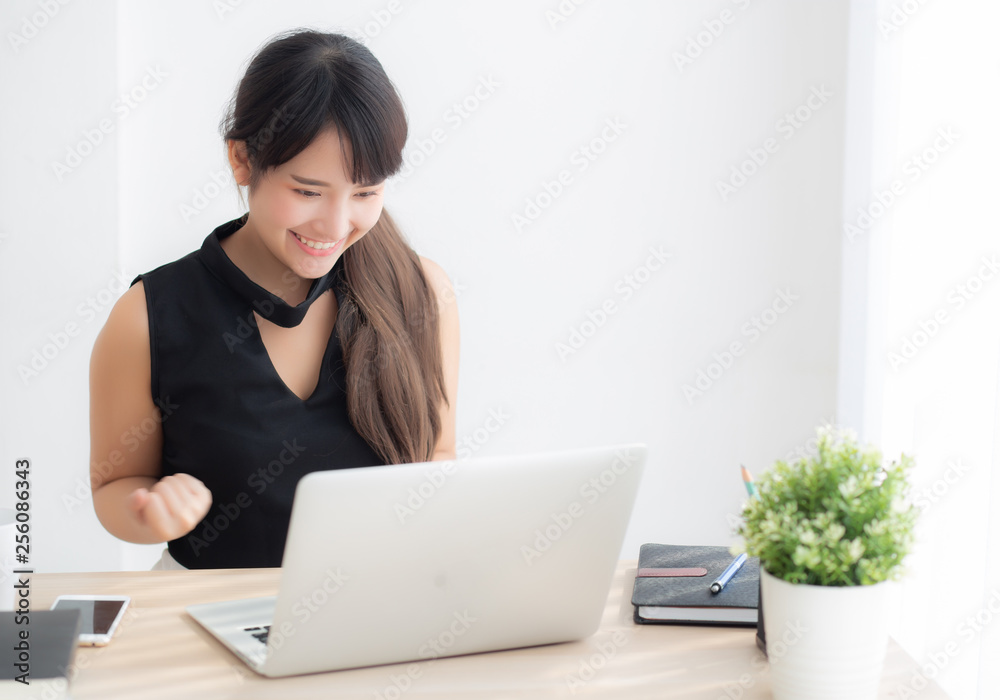 Beautiful portrait asian young woman smile working online laptop computer with happy satisfied sitting on desk office, girl using notebook with excited and glad, business and success concept. Beautiful portrait asian young woman smile working online laptop computer with happy satisfied sitting on desk office, girl using notebook with excited and glad, business and success concept.