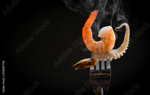 Shrimp on fork / Cooked seafood shrimps prawns mussel squid tentacles of octopus ocean gourmet dinner photo