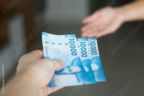 Hands giving and receiving chilean money notes. Chile ten thousand (10000) pesos. Selective focus. photo