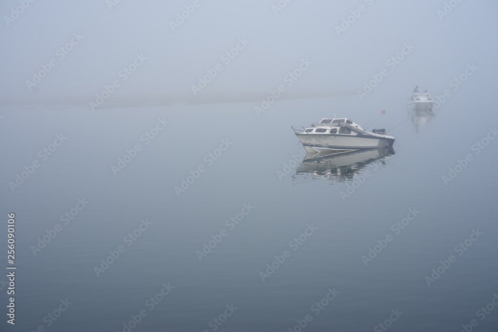 boat docked in lake with fog background