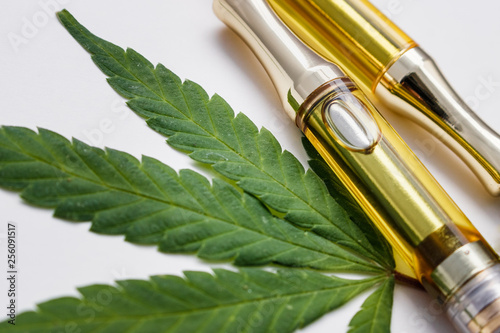 Cannabis Oil Extract In Vape Pen Cartridges Up Close On Cannabis Leaf Against White photo