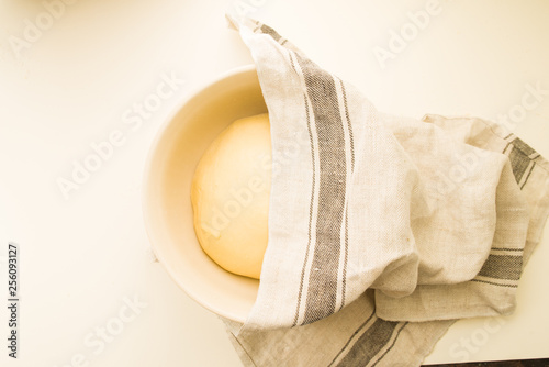 Step by step recipe to prepare a tasty challah, ingredients list  500 grams of baking wheat on a big  porcela jar, top view over a yellow background, check the ther image of the series. photo