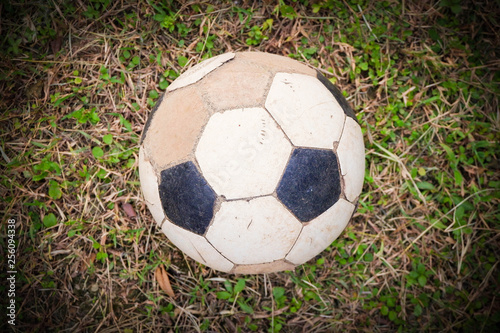 Old soccer ball in rustic football field in the countryside