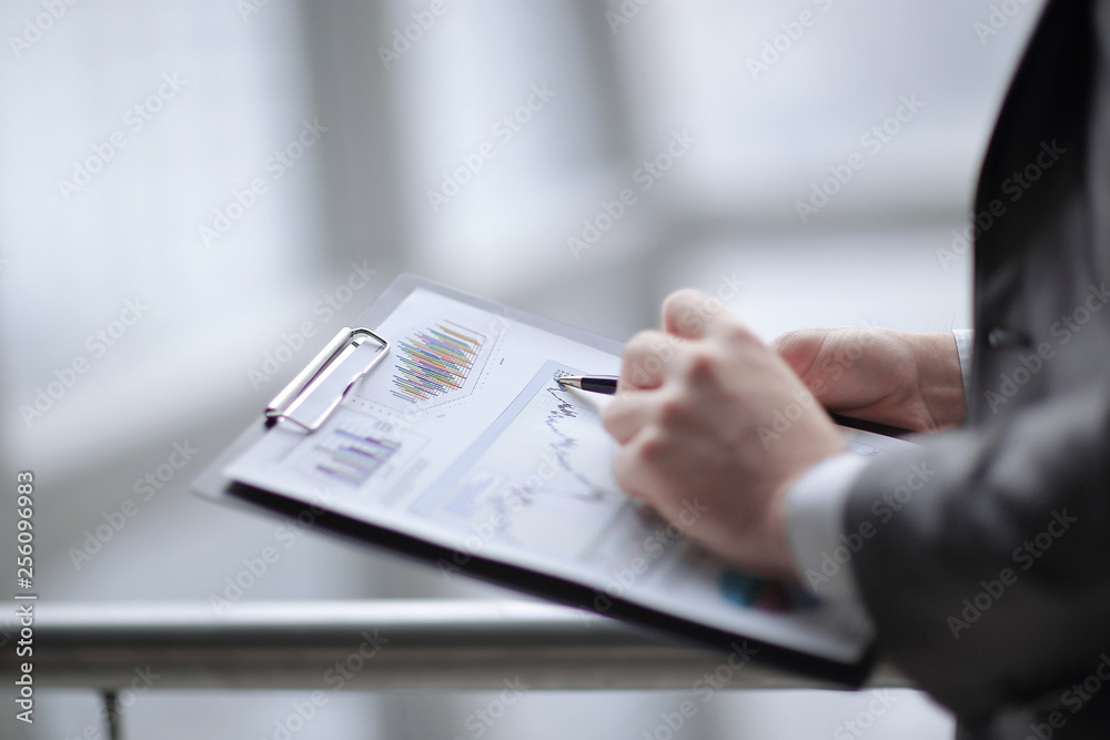 close up.businessman checking sales schedule.photo on blurred background close up.businessman checking sales schedule.photo on blurred background