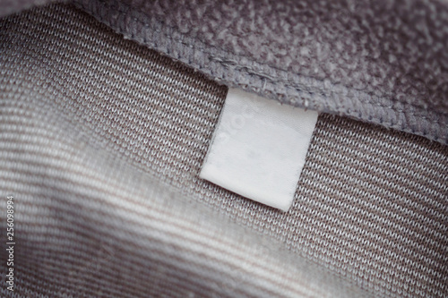 blank white clothing label on gray fabric texture background