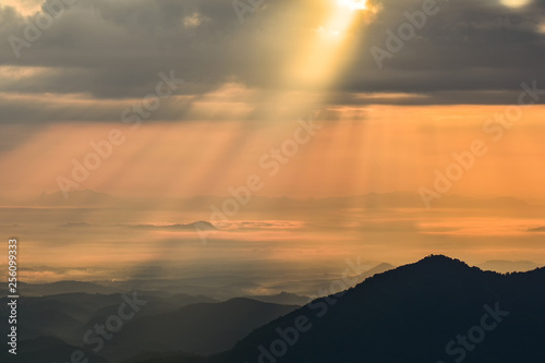 Wonderful landscape sunrise on hill mountain with rays of sunlight shining on the cloud sky