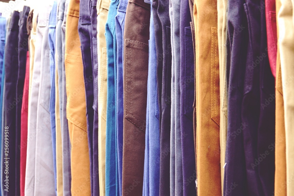 close up Many colorful jeans hanging on rack close up Many colorful jeans hanging on rack