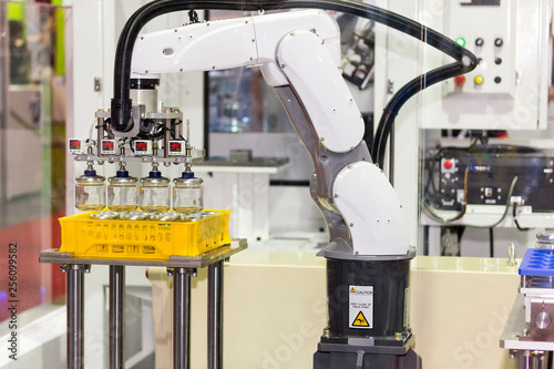 high technology of precision and accuracy industrial robot arm during working glass bottle lift from plastic box with automatic vacuum grip at factory