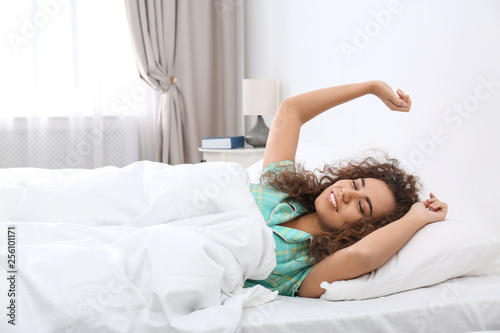 Young African-American woman stretching at home. Bedtime