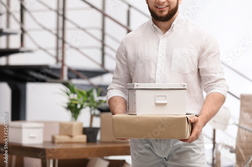 Man holding moving boxes in new office, closeup. Space for text