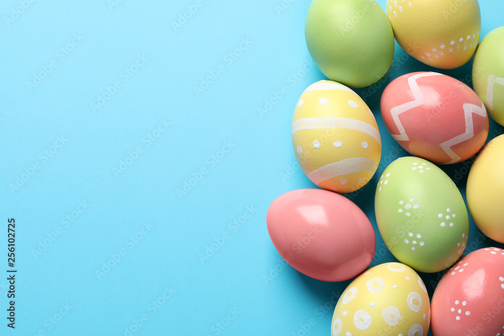 Beautiful painted Easter eggs on color background, flat lay. Space for text