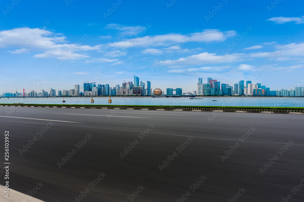 Obraz premium Foreground highway asphalt pavement city building commercial building office building
