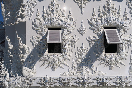 Persiennes ouvertes sur mur de temple blanc photo