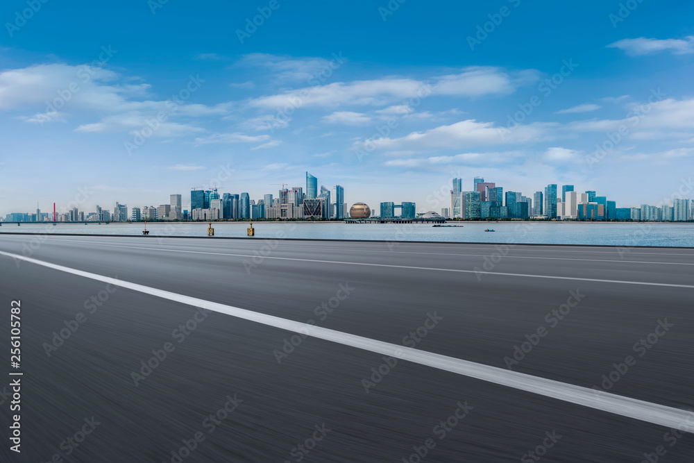 Fototapeta premium Foreground highway asphalt pavement city building commercial building office building