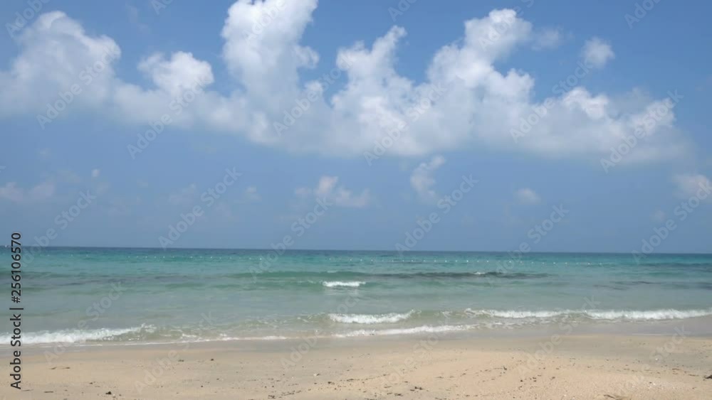 Steady shot of paradise beach, fluffy clouds and gentle waves washing shore Steady shot of paradise beach, fluffy clouds and gentle waves washing shore