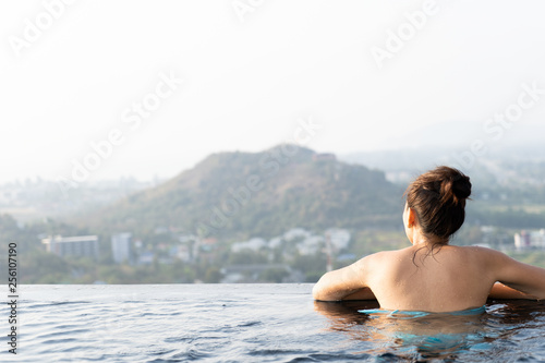 Women relax in swimming pool with mountain view and sunrise
