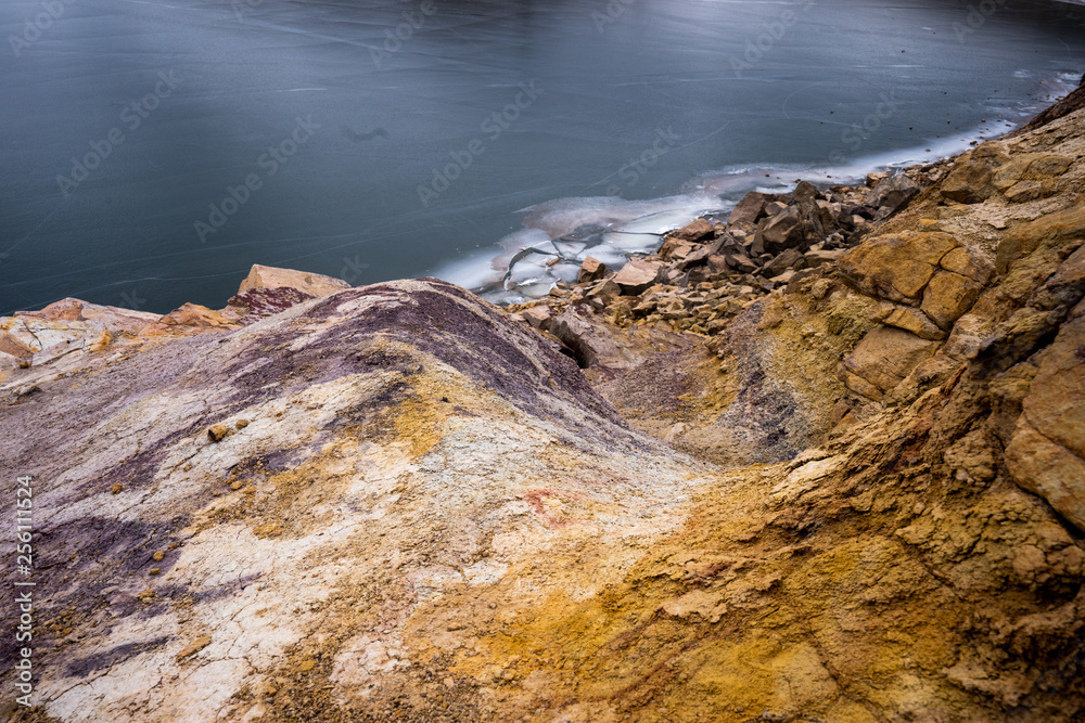 Colorful rocks by frozen reservoir
