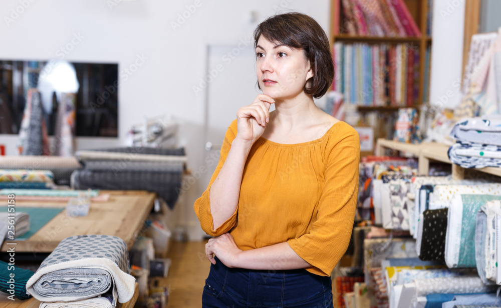 Thoughtful woman in fabric shop