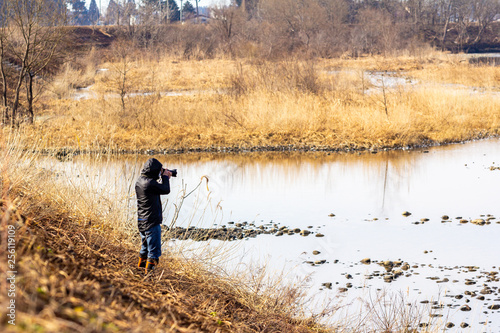 川で風景写真を撮影する男性カメラマン