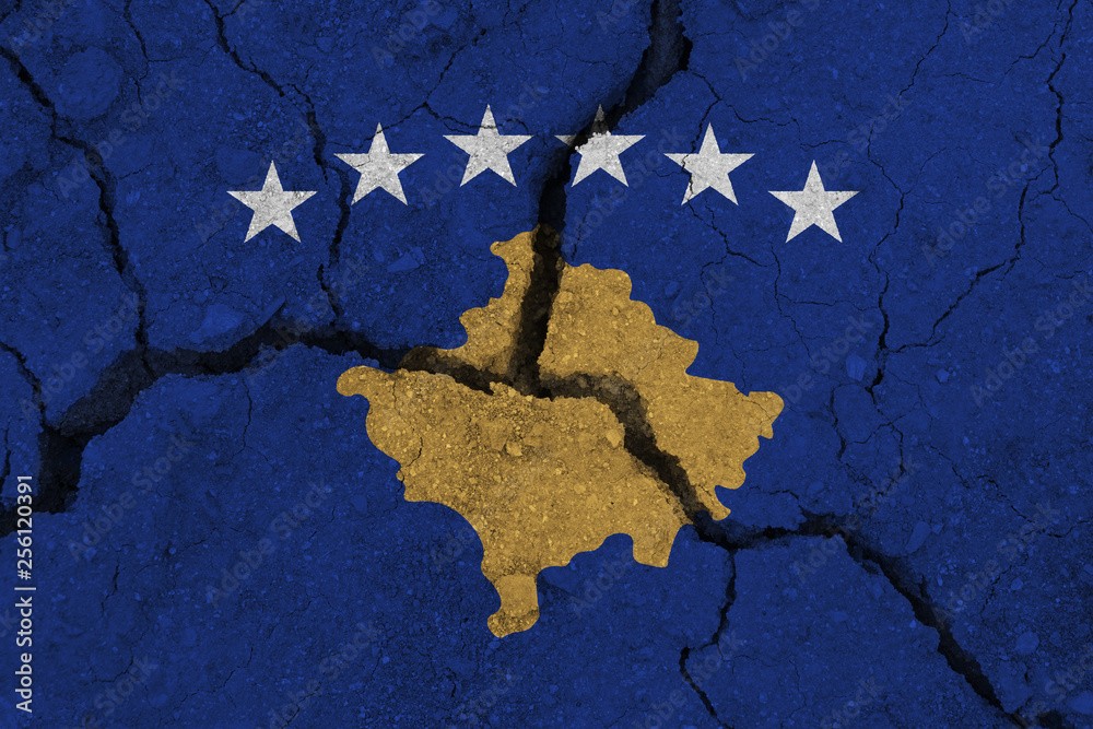 Kosovo flag on the cracked earth