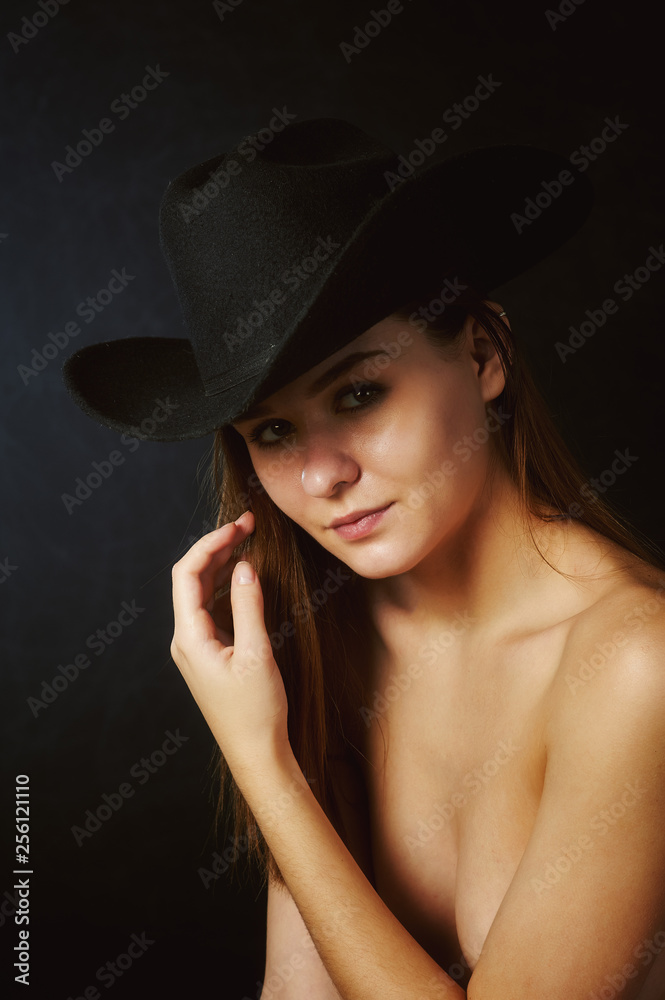 Portrait of young beautiful woman in hat in Studio on dark background Portrait of young beautiful woman in hat in Studio on dark background